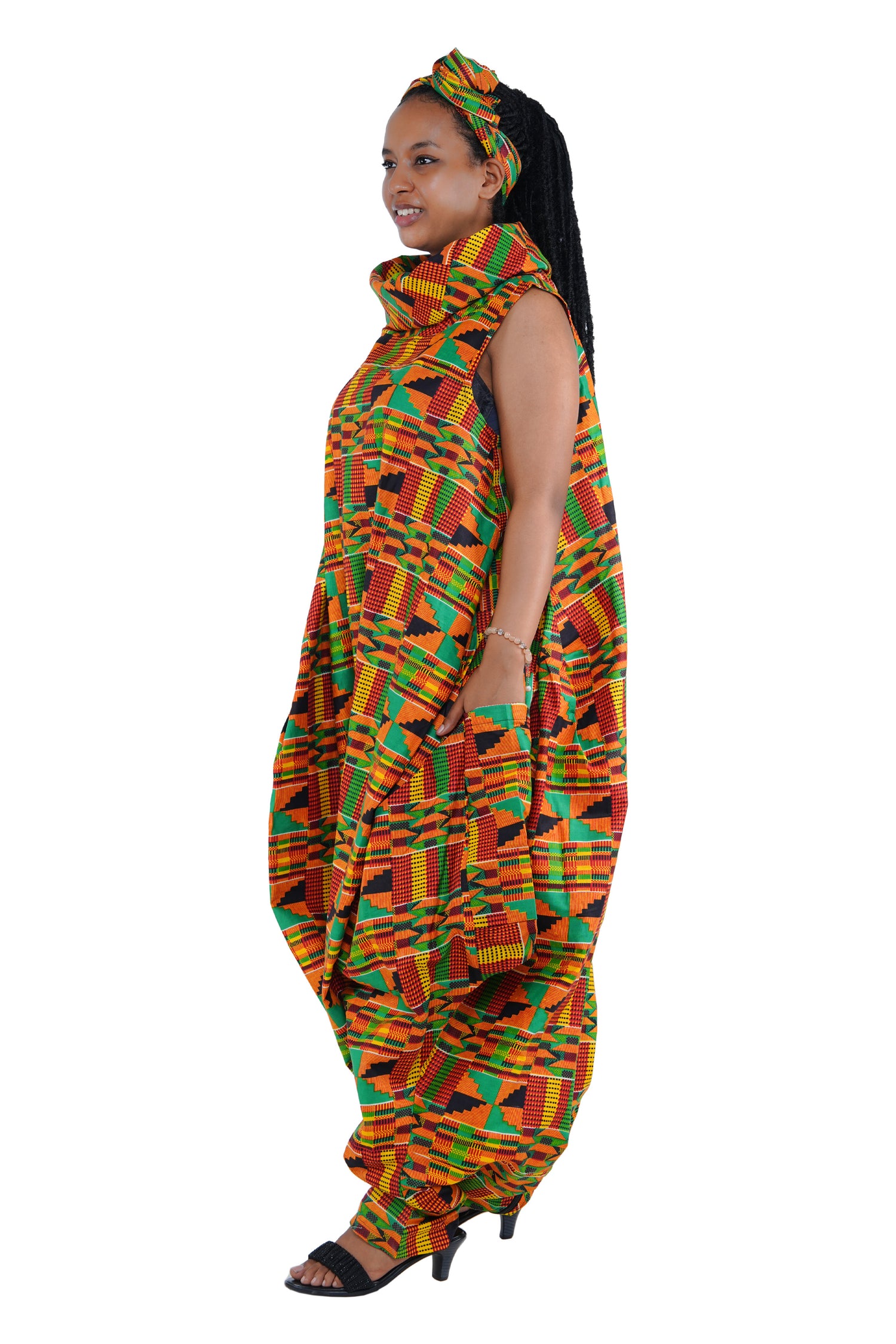 Elegant African woman wearing long high neck jumpsuit with matching headwrap in traditional print – 100% cotton, includes side pockets.