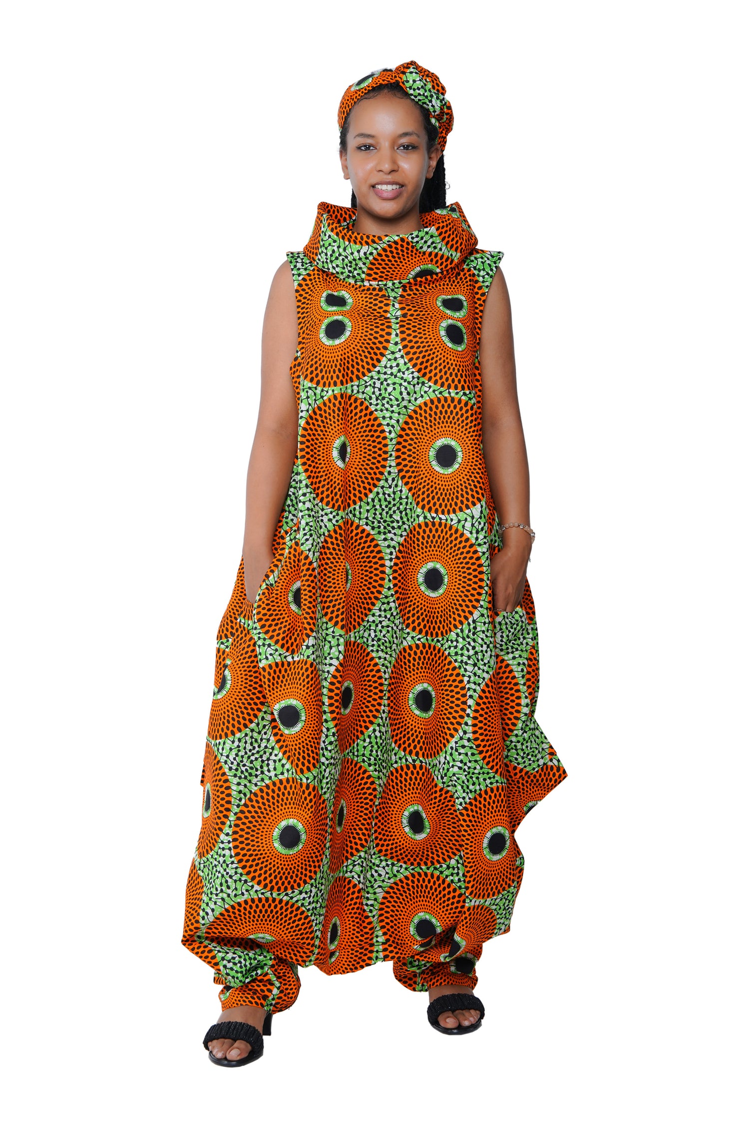 Elegant African woman wearing long high neck jumpsuit with matching headwrap in traditional print – 100% cotton, includes side pockets.