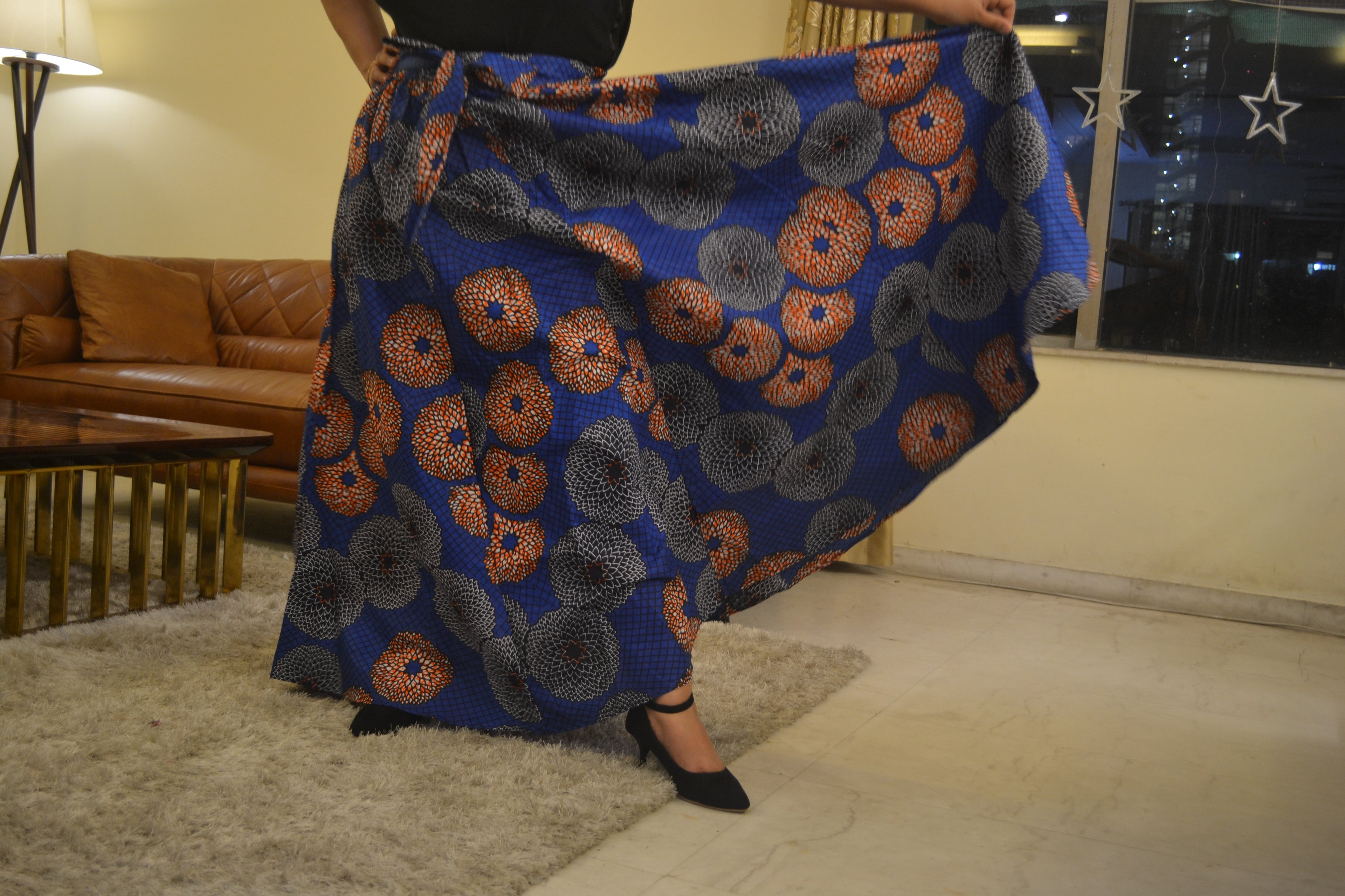 Woman wearing African print long maxi skirt in bold Ankara fabric, styled for cultural events, weddings, or everyday elegance.