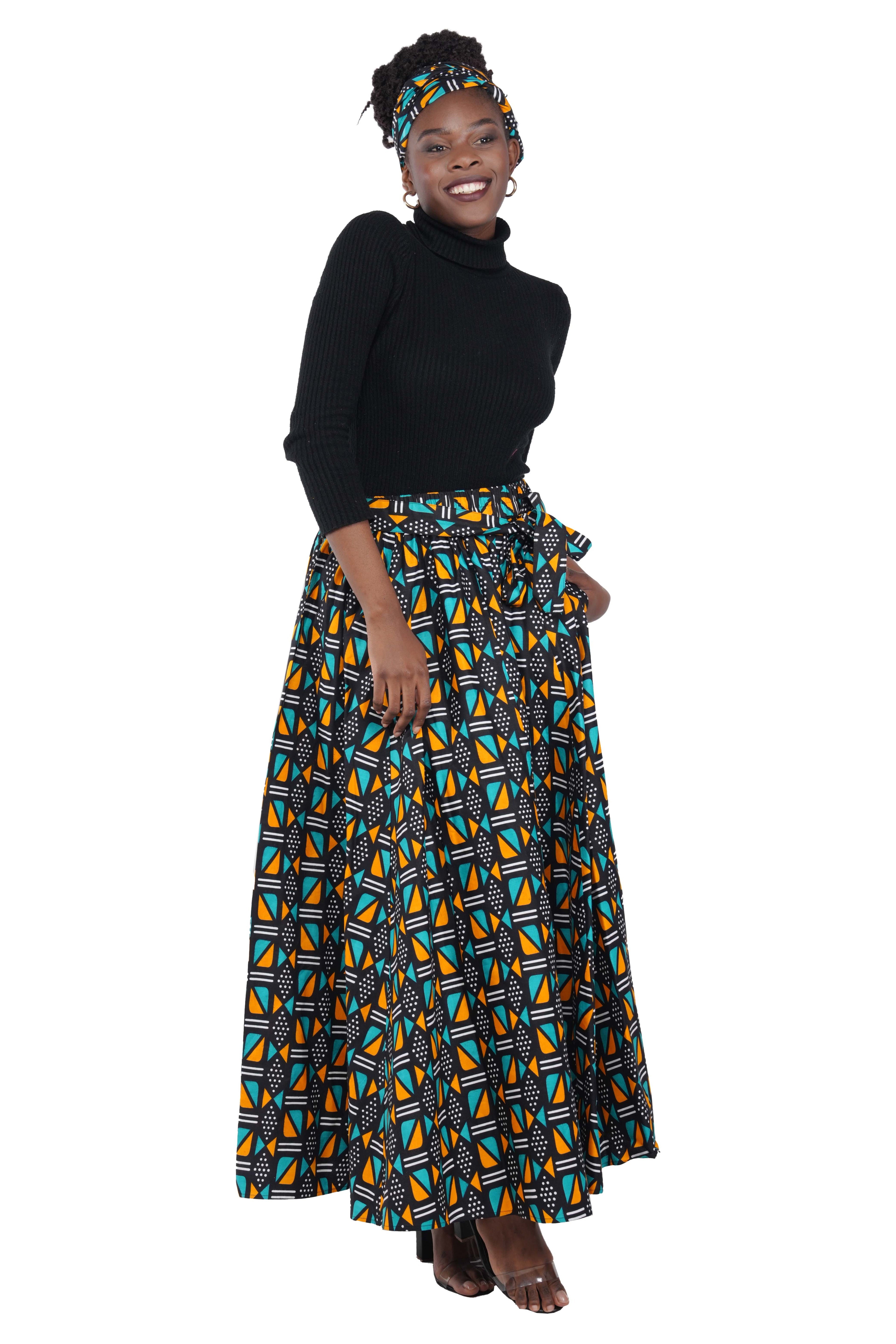 Woman wearing African print long maxi skirt in bold Ankara fabric, styled for cultural events, weddings, or everyday elegance.