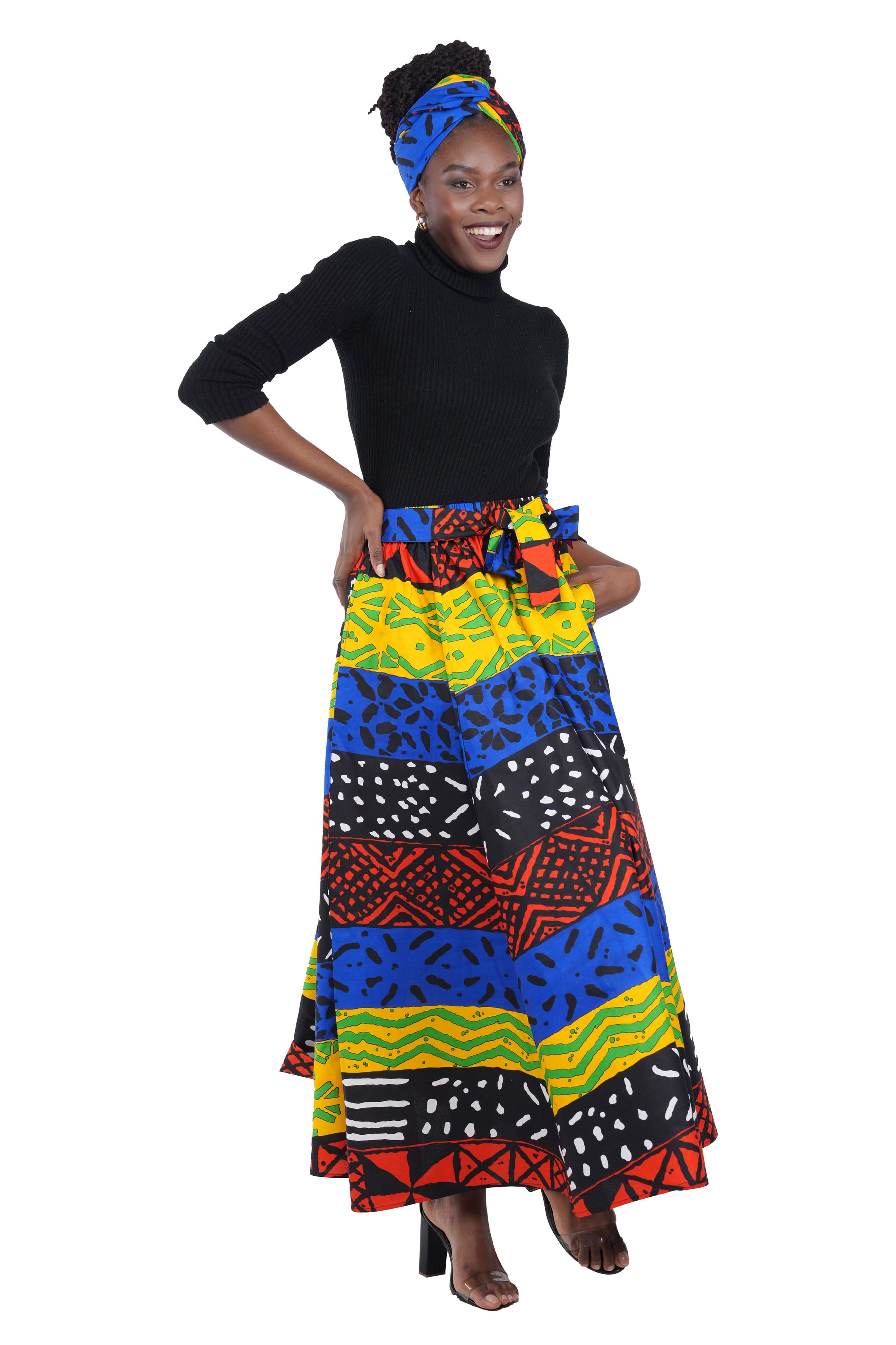 Woman wearing African print long maxi skirt in bold Ankara fabric, styled for cultural events, weddings, or everyday elegance.