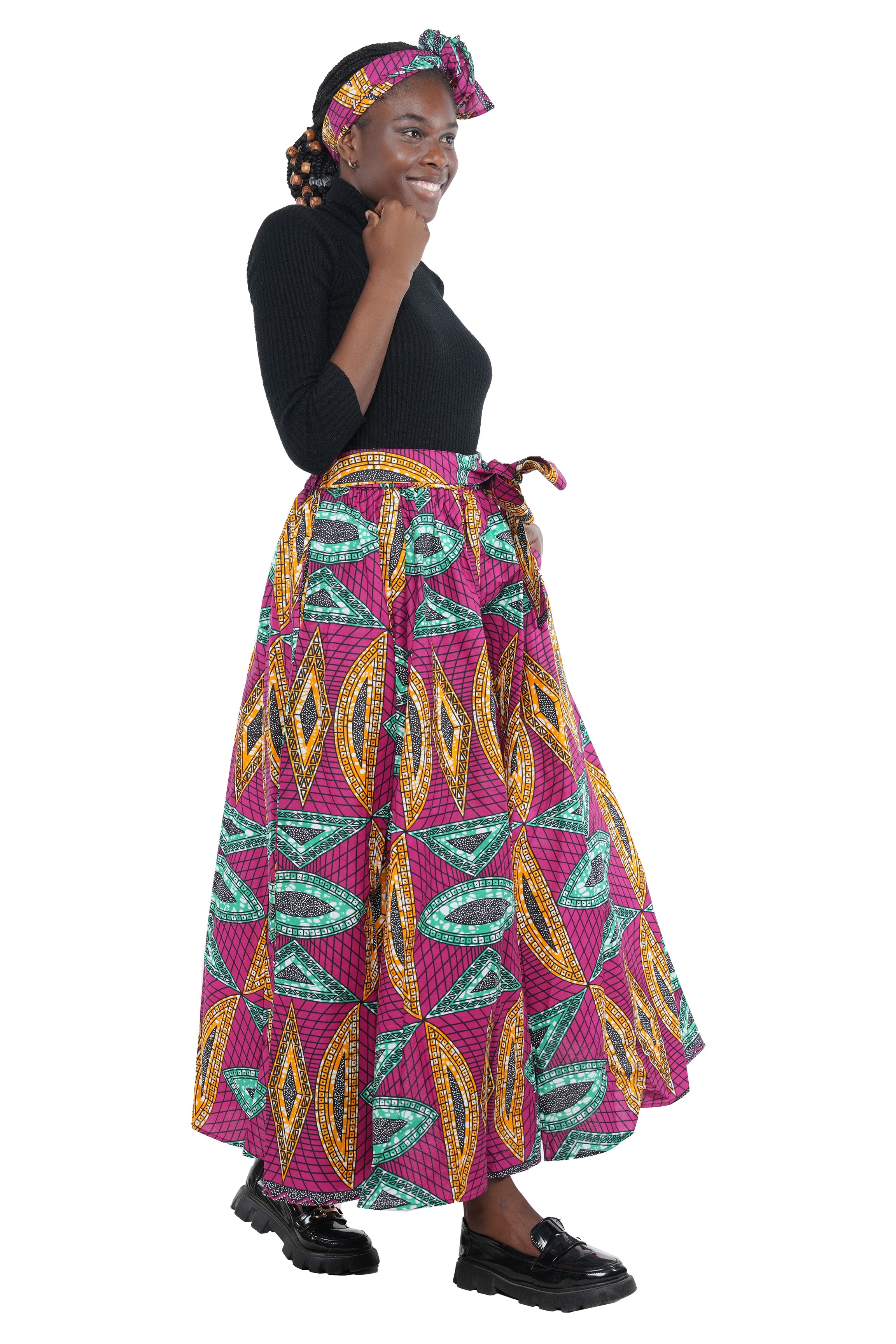 Woman wearing African print long maxi skirt in bold Ankara fabric, styled for cultural events, weddings, or everyday elegance.