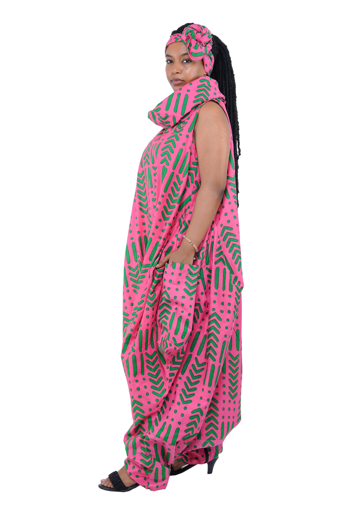 Elegant African woman wearing long high neck jumpsuit with matching headwrap in traditional print – 100% cotton, includes side pockets.