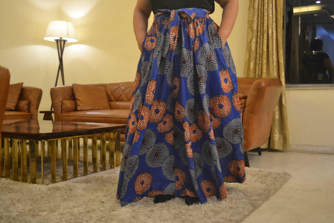 Woman wearing African print long maxi skirt in bold Ankara fabric, styled for cultural events, weddings, or everyday elegance.