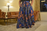 Woman wearing African print long maxi skirt in bold Ankara fabric, styled for cultural events, weddings, or everyday elegance.