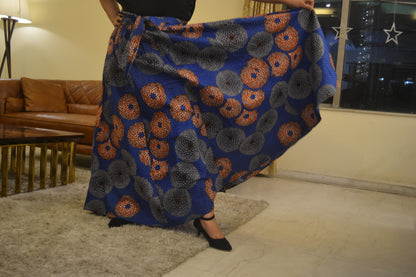 Woman wearing African print long maxi skirt in bold Ankara fabric, styled for cultural events, weddings, or everyday elegance.