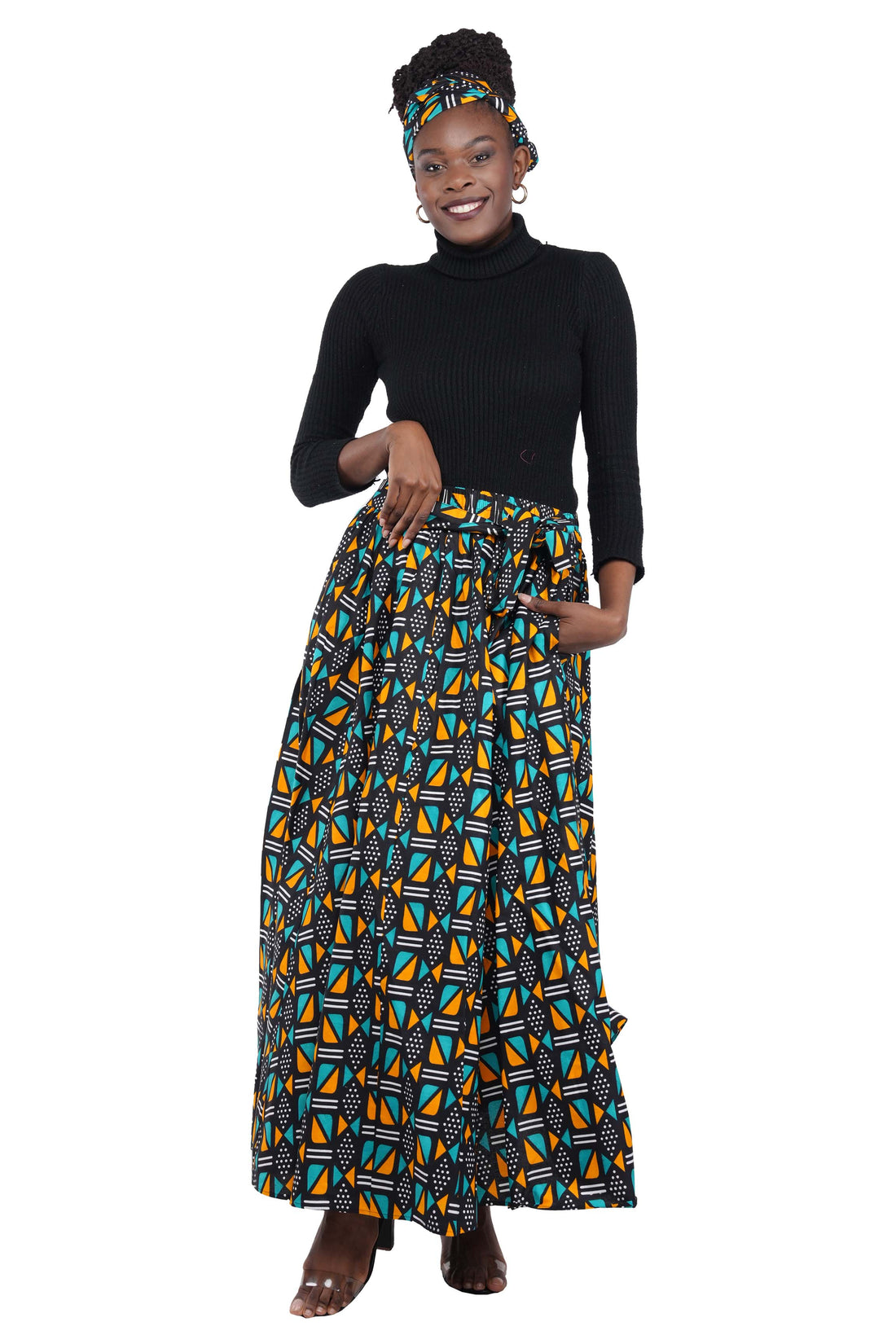 Woman wearing African print long maxi skirt in bold Ankara fabric, styled for cultural events, weddings, or everyday elegance.