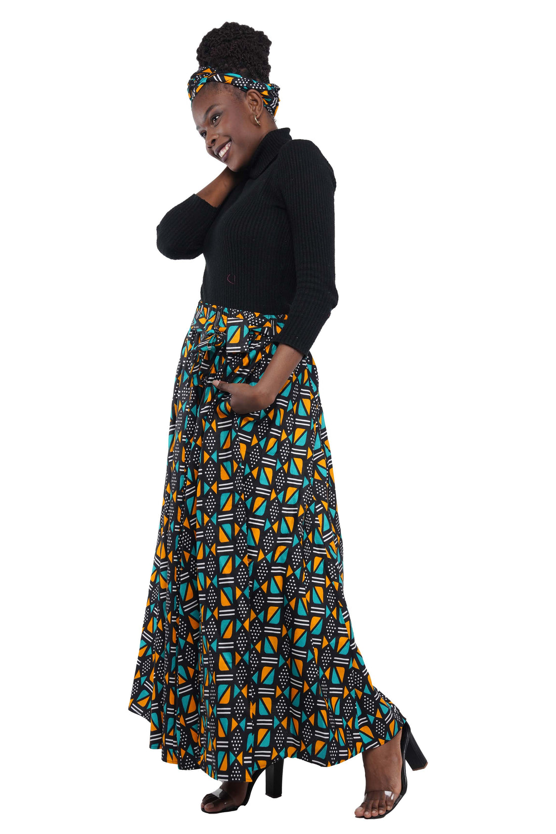 Woman wearing African print long maxi skirt in bold Ankara fabric, styled for cultural events, weddings, or everyday elegance.