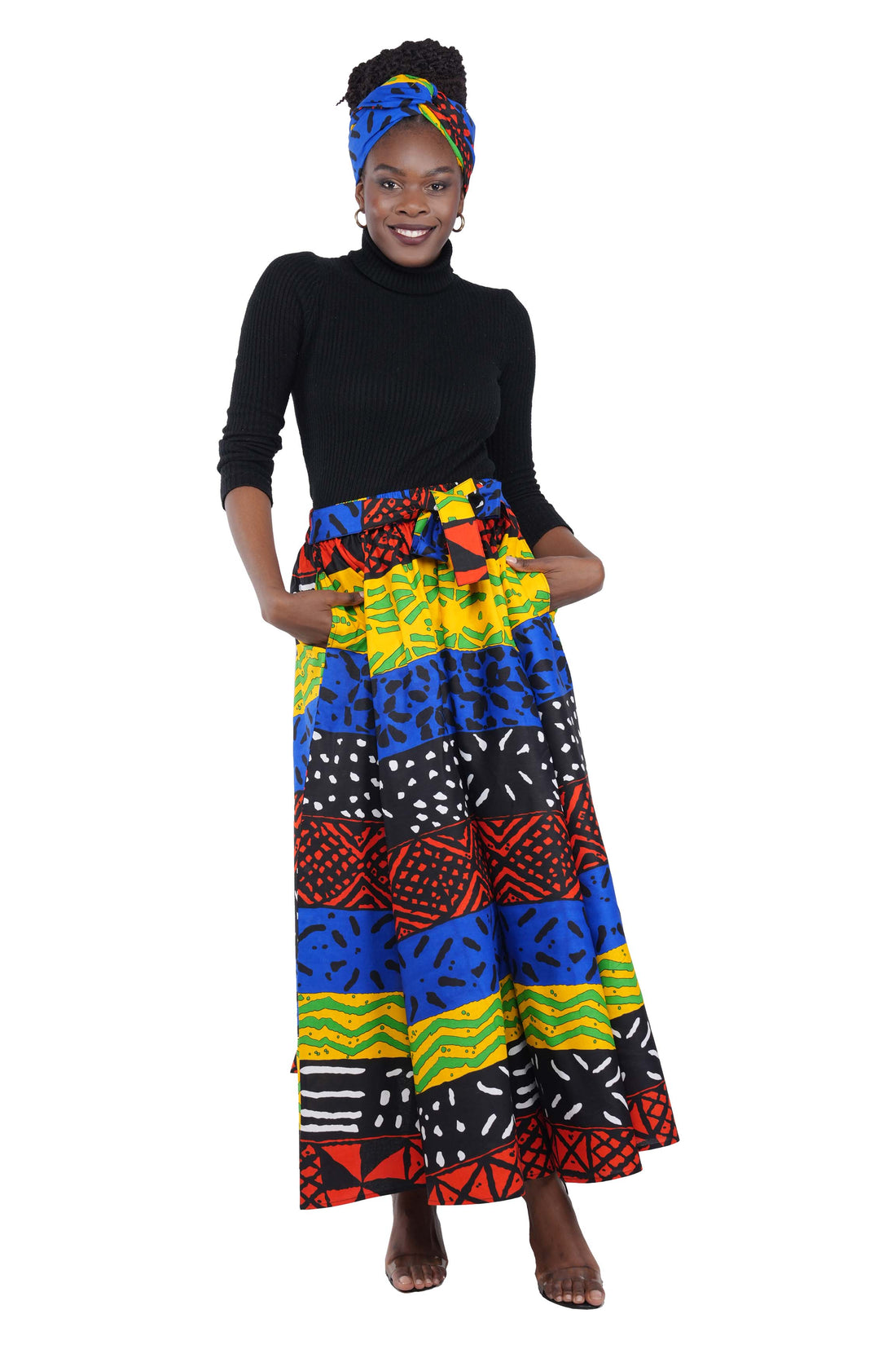 Woman wearing African print long maxi skirt in bold Ankara fabric, styled for cultural events, weddings, or everyday elegance.