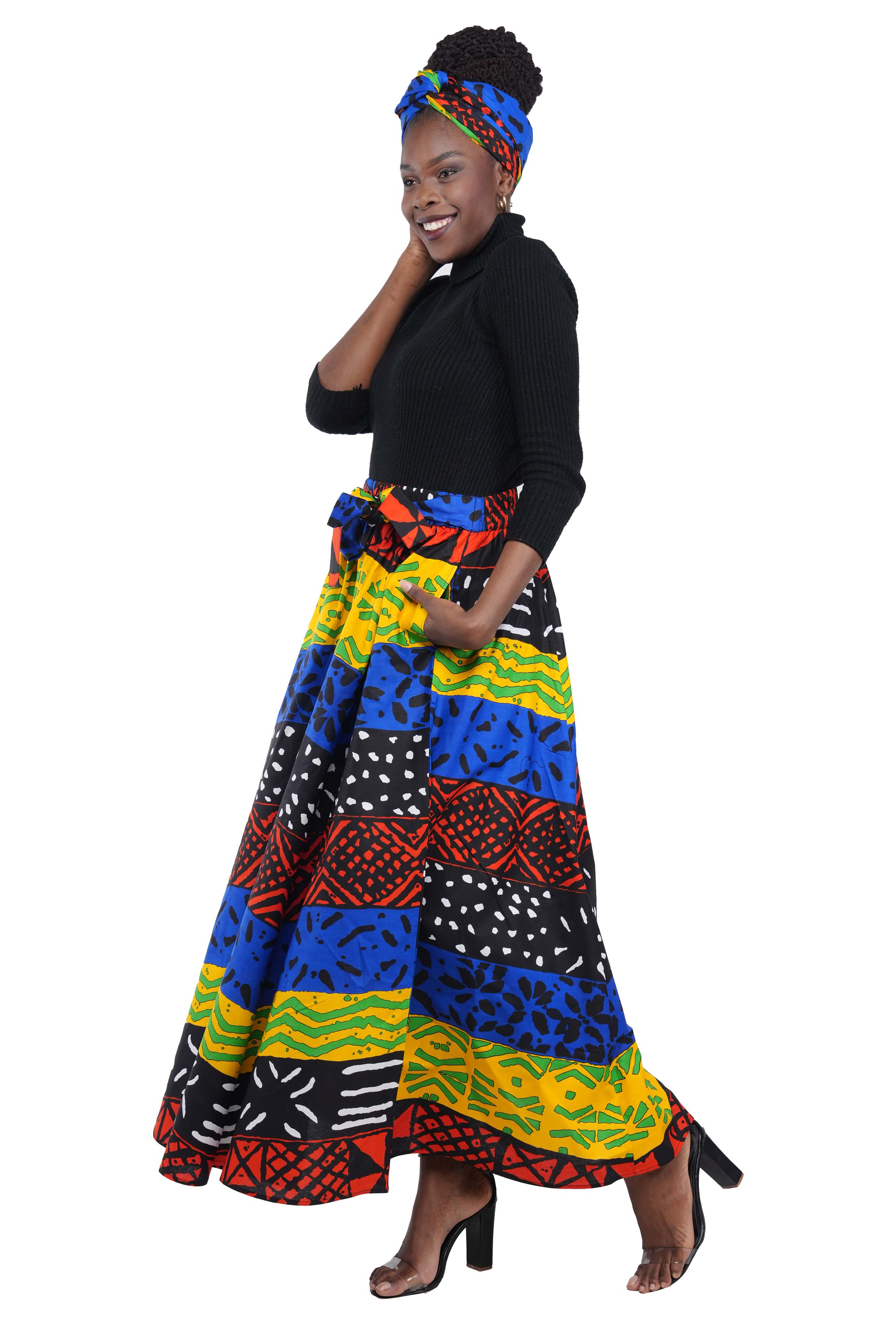 Woman wearing African print long maxi skirt in bold Ankara fabric, styled for cultural events, weddings, or everyday elegance.