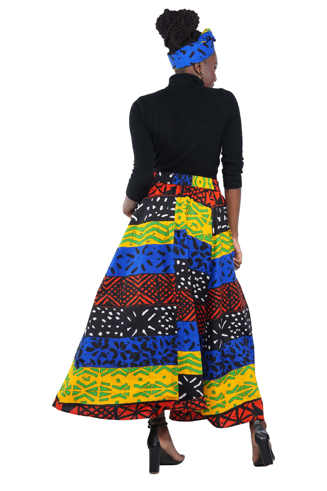Woman wearing African print long maxi skirt in bold Ankara fabric, styled for cultural events, weddings, or everyday elegance.
