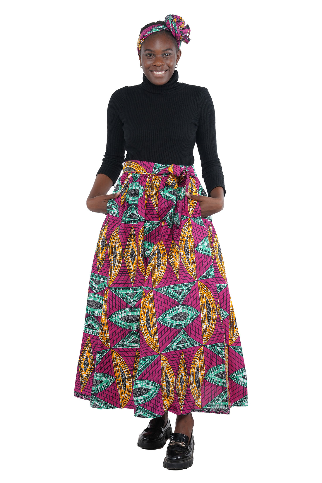 Woman wearing African print long maxi skirt in bold Ankara fabric, styled for cultural events, weddings, or everyday elegance.