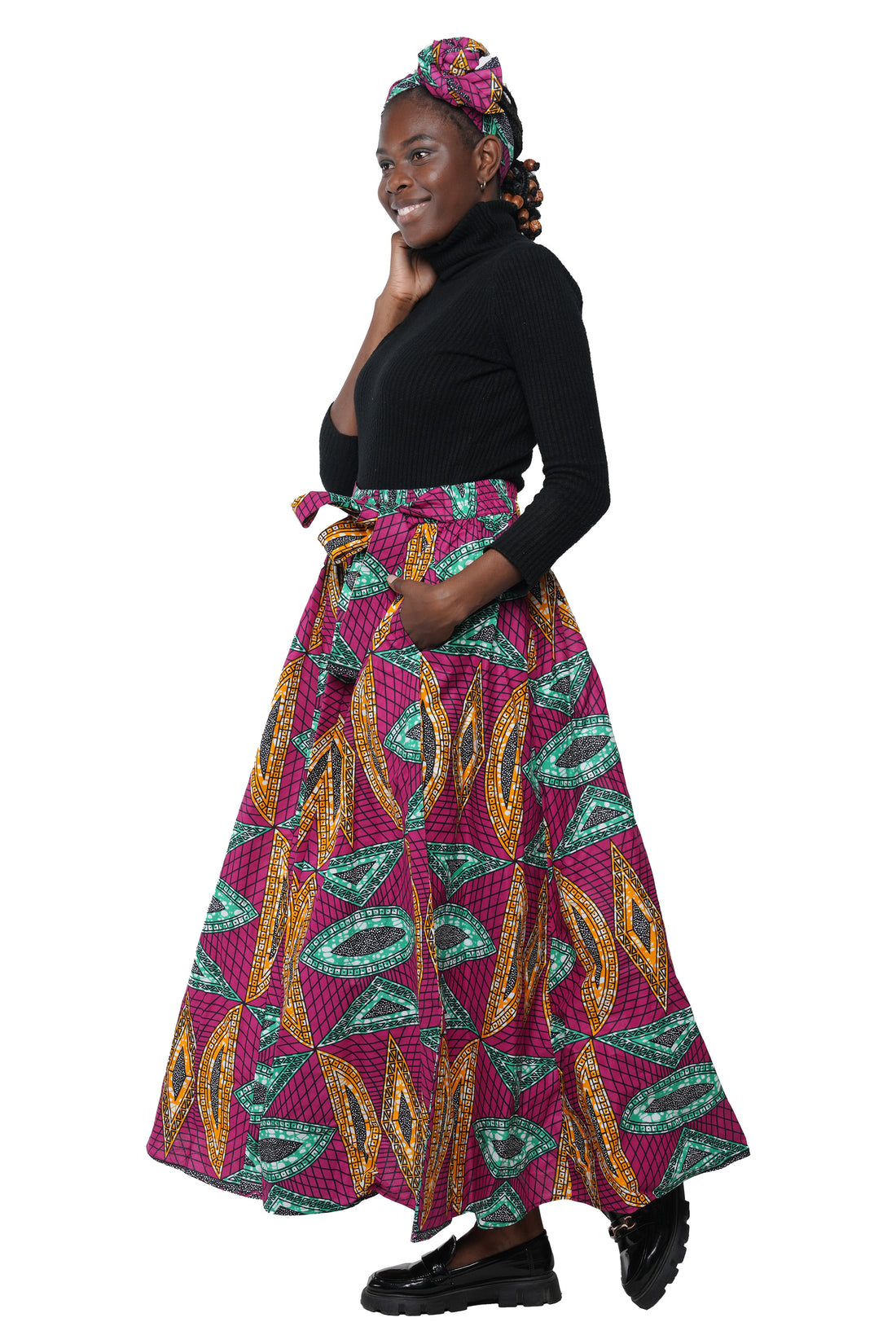 Woman wearing African print long maxi skirt in bold Ankara fabric, styled for cultural events, weddings, or everyday elegance.