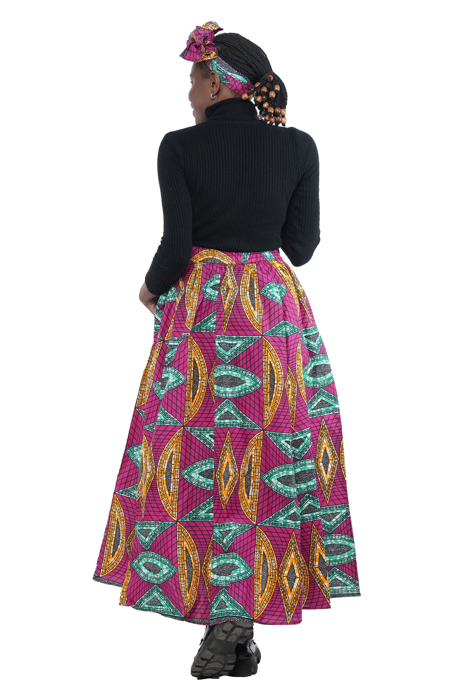 Woman wearing African print long maxi skirt in bold Ankara fabric, styled for cultural events, weddings, or everyday elegance.