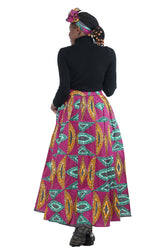 Woman wearing African print long maxi skirt in bold Ankara fabric, styled for cultural events, weddings, or everyday elegance.