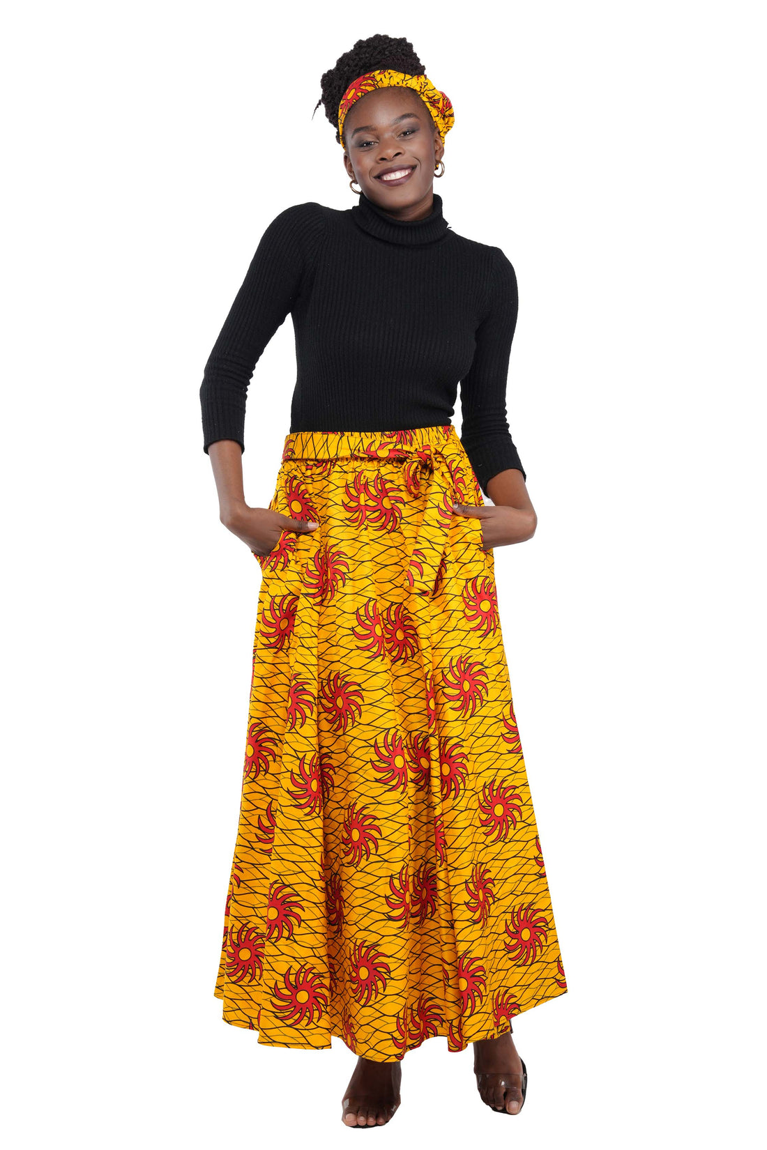 Woman wearing African print long maxi skirt in bold Ankara fabric, styled for cultural events, weddings, or everyday elegance.