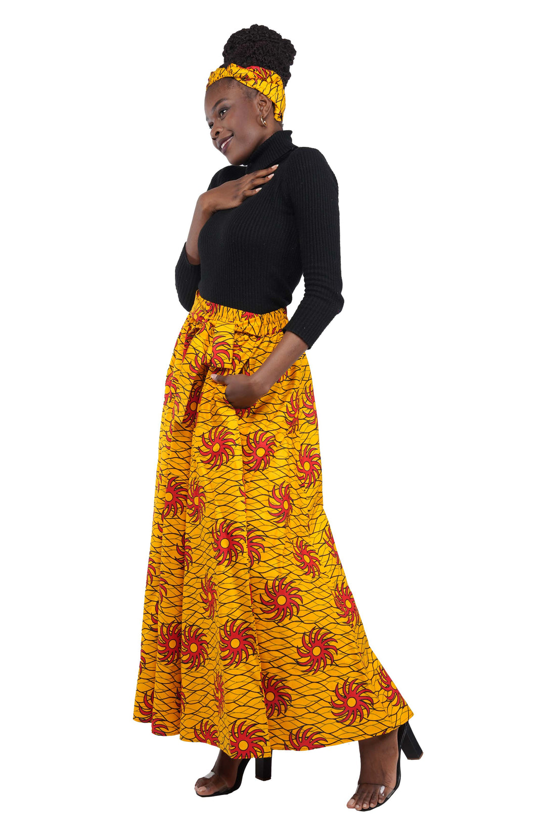 Woman wearing African print long maxi skirt in bold Ankara fabric, styled for cultural events, weddings, or everyday elegance.