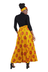 Woman wearing African print long maxi skirt in bold Ankara fabric, styled for cultural events, weddings, or everyday elegance.